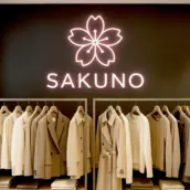 Leuchtlogo und Leuchtbuchstaben des Modelabels SAKUNO, stilvoll beleuchtet an einer Wand montiert.